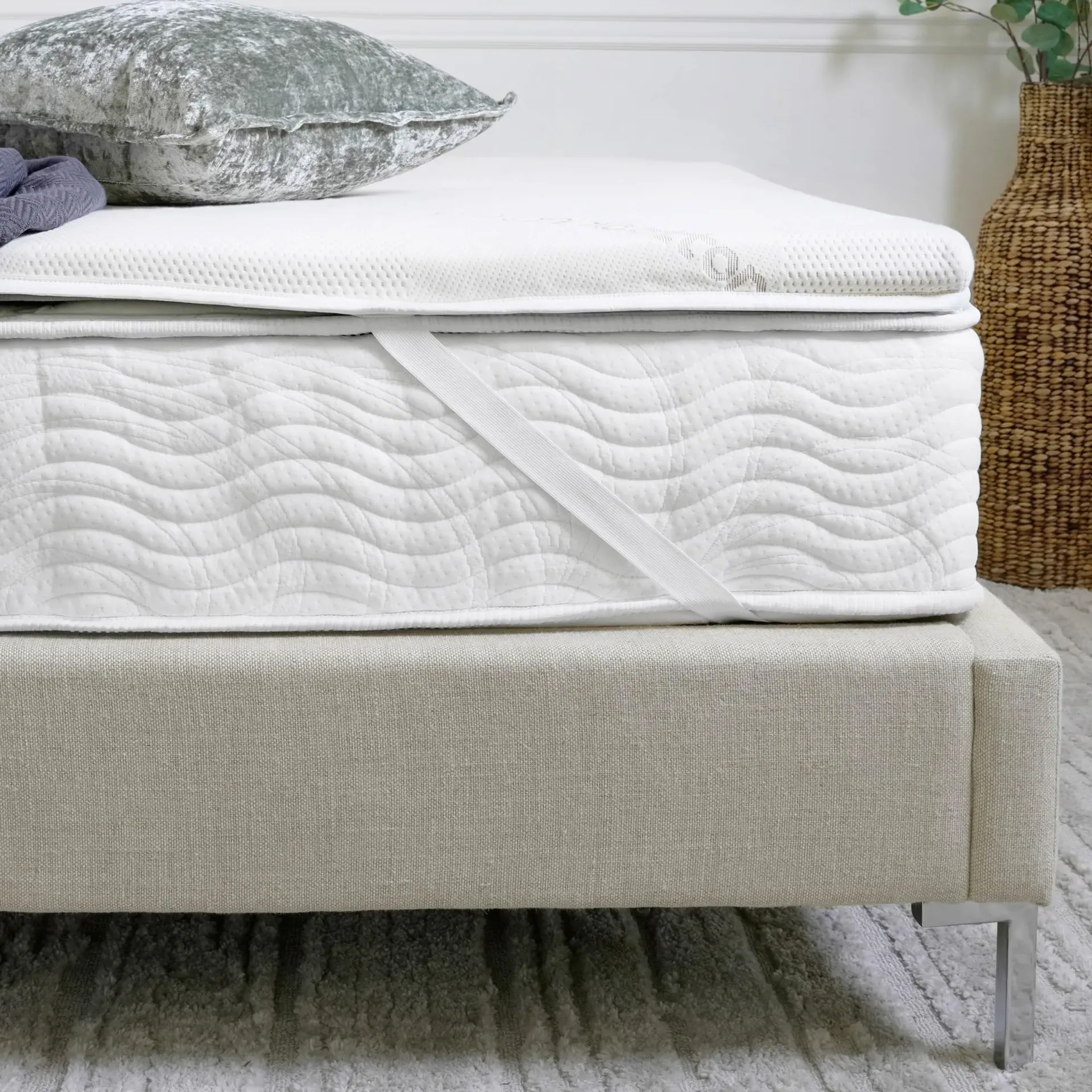 Saatva Natural Latex mattress topper with organic cotton cover on a bedroom bed